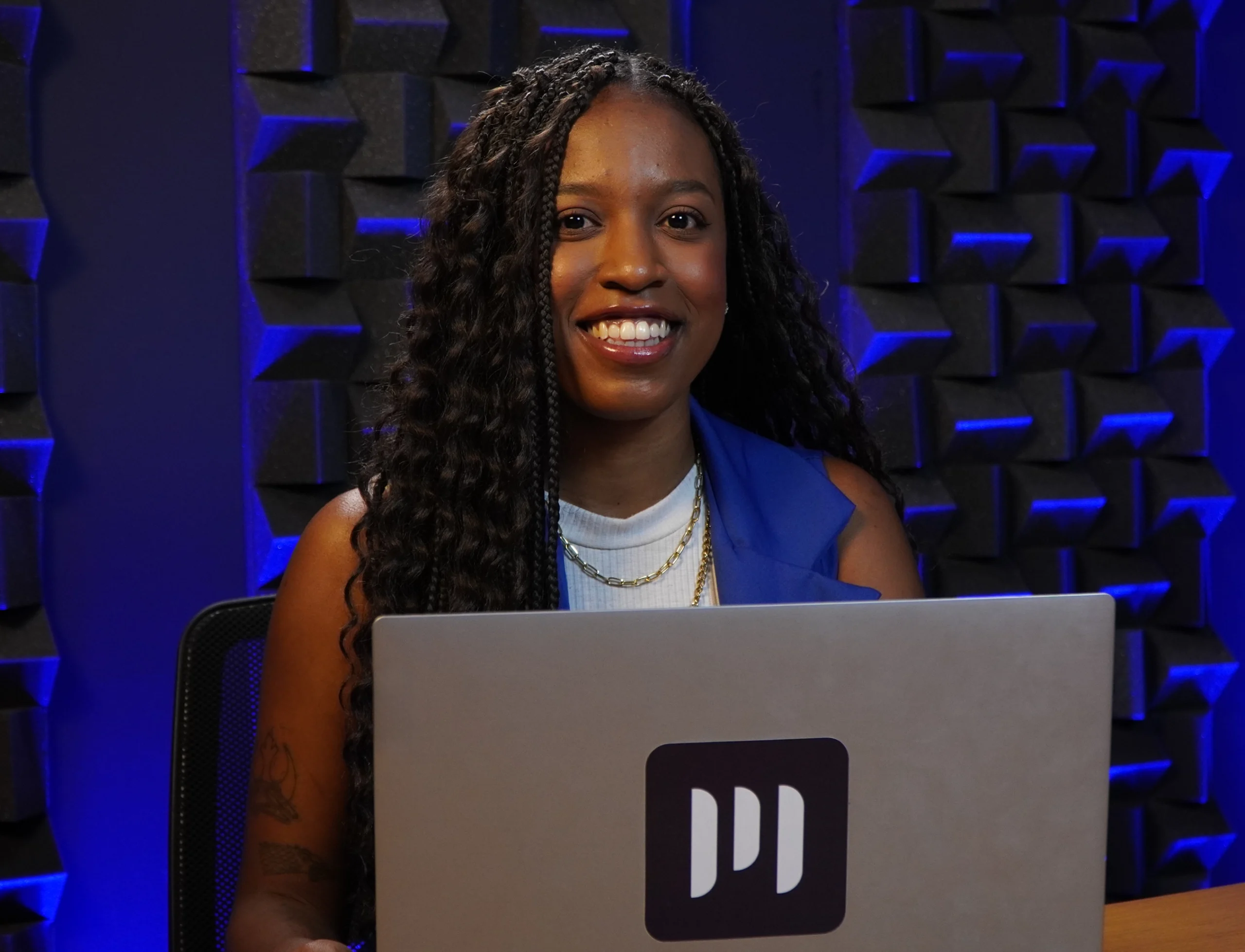 Bruna, funcionária da Makro, sorrindo enquanto trabalha em seu laptop.