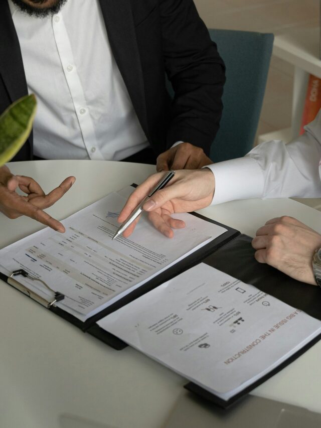 A imagem mostra uma mesa com papéis em cima, e uma caneta, representando a DIRBI.