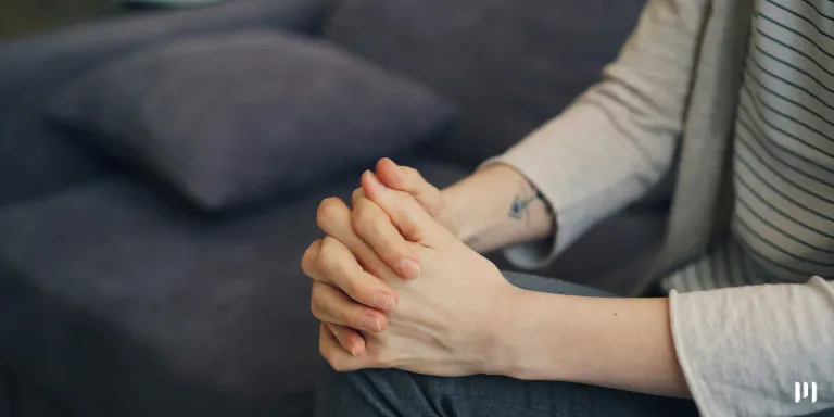 Uma mulher com as mãos juntas representando Saúde Mental do Contador