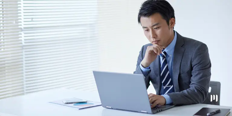 Empresário analisa dados financeiros em notebook durante consulta ao Painel Receita da Receita Federal.