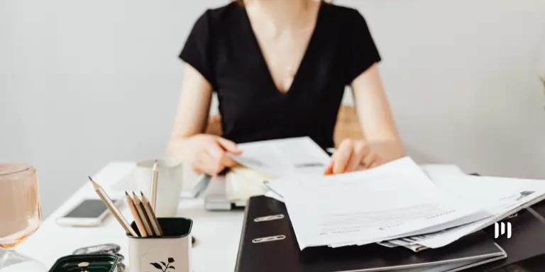 Profissional analisa documentos em escritório durante o envio dos dados do eSocial para o Abono Salarial.
