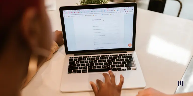 Pessoa utiliza um notebook para preencher um cadastro online, representando a atualização obrigatória no NovoPAT.