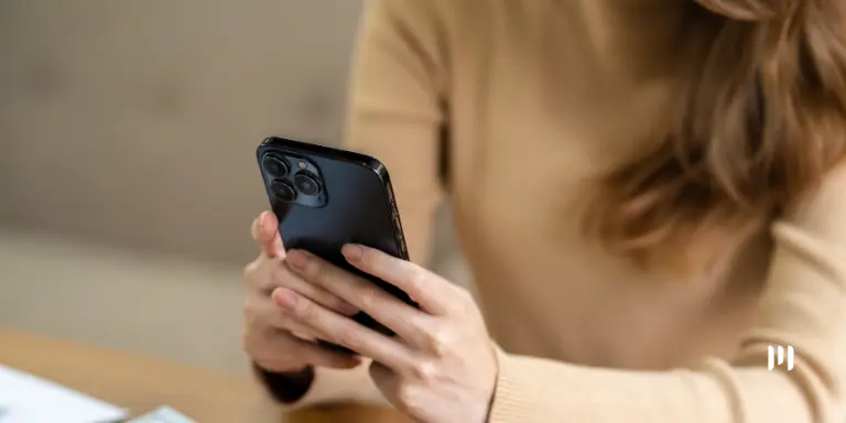 Mulher consulta informações sobre a distribuição do lucro do FGTS pelo celular.