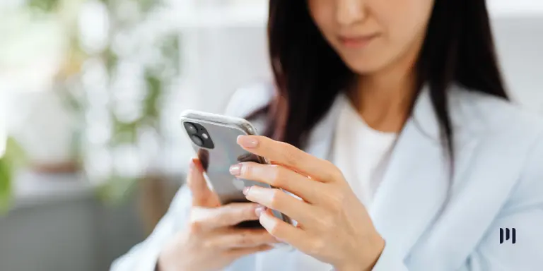 Mulher consulta informações sobre a restituição automática do IRPF em um smartphone.