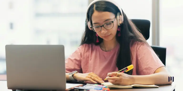 Estudante revisa anotações durante a preparação para o Exame de Suficiência CFC 2026.2 em uma mesa de estudos.