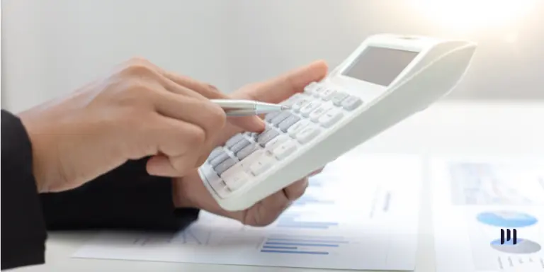 Reforma Tributária no Simples Nacional: profissional usa calculadora sobre documentos com gráficos financeiros.